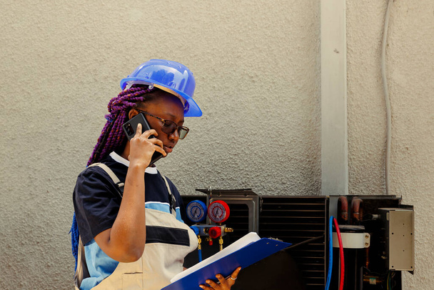 Афроамериканський учень інформує майстра по телефону про деталі кондиціонера, необхідні для заміни. План технічного обслуговування механічної перевірки після очищення повітряних фільтрів - Фото, зображення