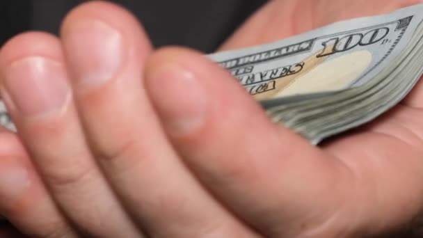 Close-up van een man met een stapel dollars in zijn handen. De man werd omgekocht. Vuil geld. Verticale video - Video
