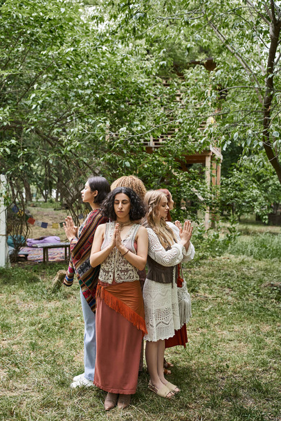 interracial women doing praying hands gesture while standing on lawn in retreat center - Photo, Image