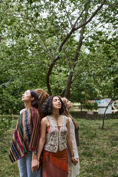 glimlachende interraciale vrouwen hand in hand, terwijl staan rug aan rug in retraite centrum - Foto, afbeelding