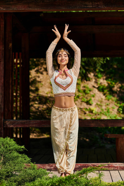 Otantik bir stil, yaz parkı, geleneksel Hintli genç bir kadın gözleri kapalı dans ediyor. - Fotoğraf, Görsel