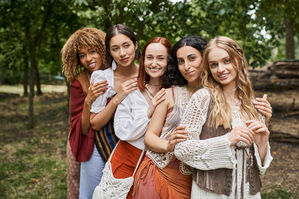portrait of cheerful and stylish women in boho styled clothes looking at camera in retreat center - Photo, Image