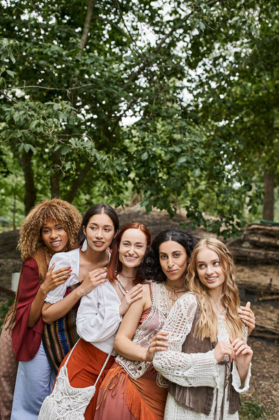 joyful multiethnic group of women looking at camera and hugging in retreat center - Photo, Image