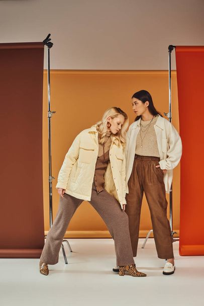 Herbstmode, junge interrassische Frauen in Herbstkleidung posieren vor pastellfarbener Kulisse - Foto, Bild