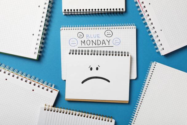 Blocos de notas com texto Blue Monday e emoji triste no fundo azul, vista superior - Foto, Imagem