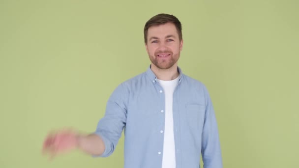 Atraktivní veselý chlap ukazuje ok reklamní cedule izolované přes jasně zelenou barvu pozadí. Koncepty životního stylu. Svislé video - Záběry, video