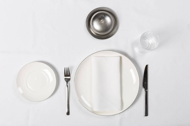 Různé podnosy s talířem, vidličkou, nožem na bílém stole - Fotografie, Obrázek