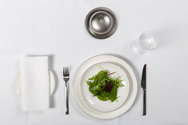 Various setup servings with plate, fork, knife on white table - Photo, Image