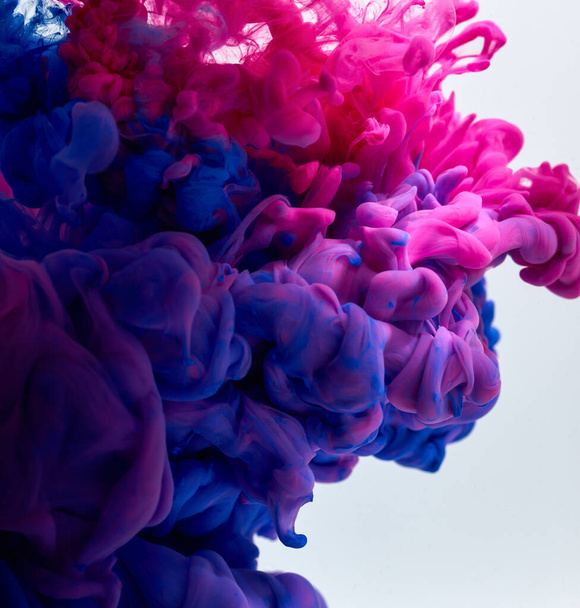 Splash των χρωμάτων στο νερό πάνω από γκρι φόντο - Φωτογραφία, εικόνα