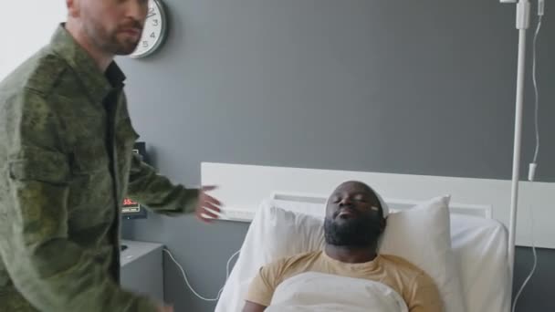 Soldado visitando a amigo inconsciente en hospital militar presenciando paro cardíaco y llamando al médico para realizar RCP - Metraje, vídeo