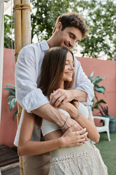 homem alegre e mulher bonita em traje de verão branco em pé juntos ao ar livre, ligação casal - Foto, Imagem