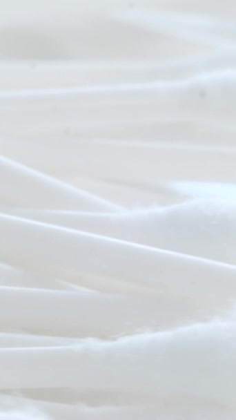 Műanyag pamut törlőkendő fehér alapon. Makró videó. Függőleges videó - Felvétel, videó