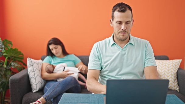 Молодой отец с семьей пользуется ноутбуком дома - Фото, изображение