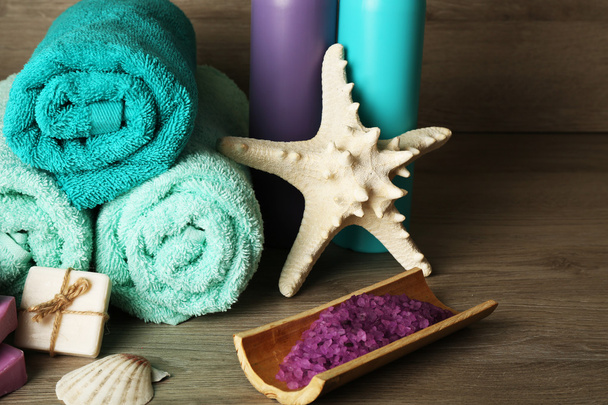 Spa composition with towels and sea salt on wooden background - Fotografie, Obrázek