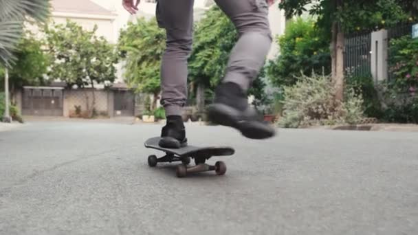 Przycięty strzał nogi człowieka korzystających z jego jazdy na deskorolce na ulicy - Materiał filmowy, wideo