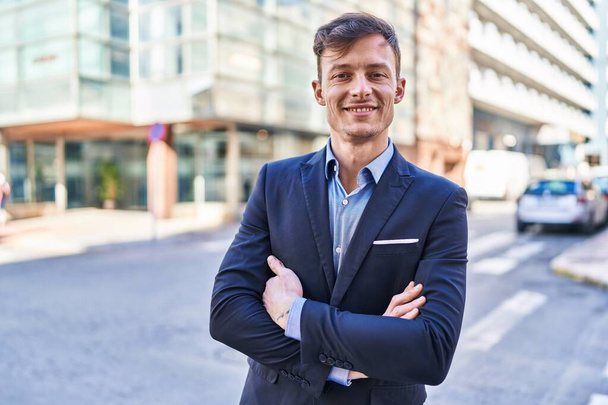 Young man business worker smiling confident standing with arms crossed gesture at street - Photo, Image
