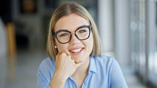 Jeune femme blonde travailleur d'affaires souriant confiant au bureau - Photo, image