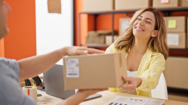 Работник электронной коммерции мужчина и женщина передают пакет клиенту в офисе - Фото, изображение