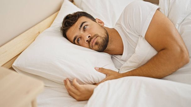 Joven hispano acostado en la cama en el dormitorio - Foto, Imagen