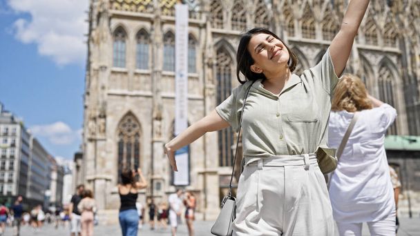 Jonge mooie Spaanse vrouw met open armen in St. Stephen 's Cathedral - Foto, afbeelding