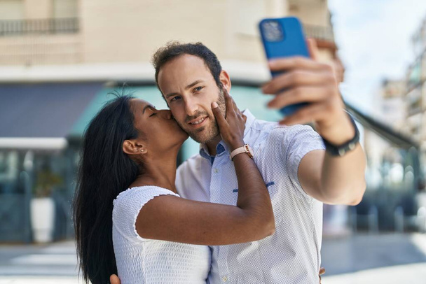 mężczyzna i kobieta międzyrasowy para co selfie przez smartfon na ulicy - Zdjęcie, obraz