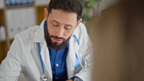 Jovem hispânico homem médico ter consulta médica com o paciente na clínica - Foto, Imagem