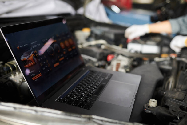 Mechanica met behulp van programma op laptop bij het analyseren van auto computersystemen en onderdelen - Foto, afbeelding