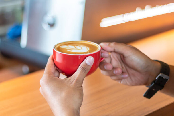 Mãos femininas segurando xícara de café na barra de mesa. visão perspectiva. cafetaria. - Foto, Imagem