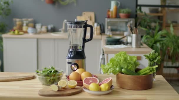 Arco médio tiro de frutas frescas, legumes e liquidificador para fazer smoothie na mesa da cozinha - Filmagem, Vídeo