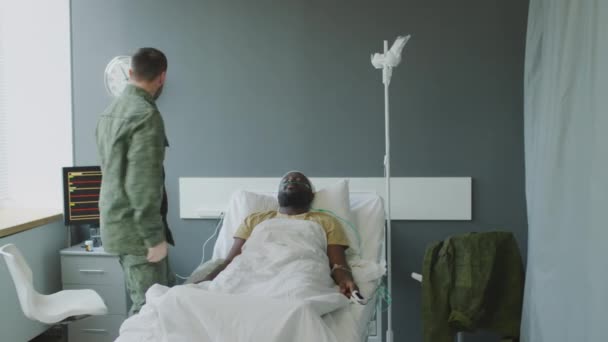 Militar presenciando el estado crítico de su amigo inconsciente llamando al médico para rescatarlo - Metraje, vídeo
