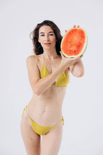 Chica atlética delgada en traje de baño de verano sostiene la sandía. Descanso, vacaciones por mar. mujeres Salud - Foto, imagen