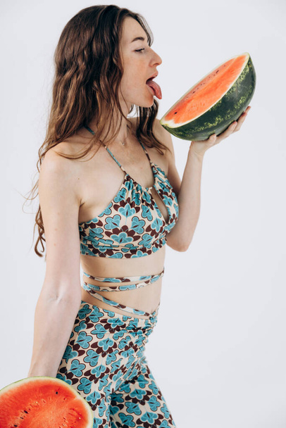 Slank atletisch meisje in de zomer badpak houdt watermeloen. Rust, vakantie aan zee. Vrouwen Gezondheid - Foto, afbeelding