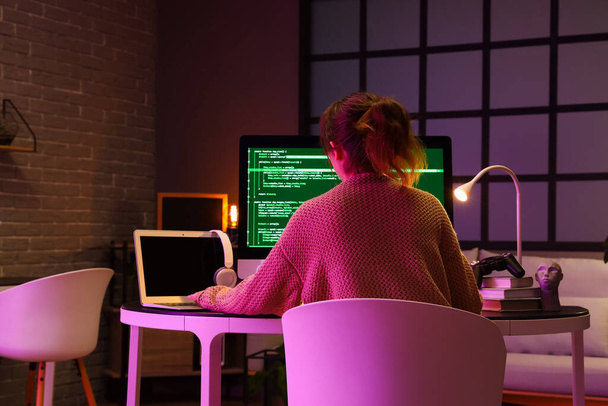 Vrouwelijke programmeur aan tafel in kantoor, achteraanzicht - Foto, afbeelding