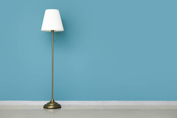 Біла стандартна лампа біля синьої стіни - Фото, зображення