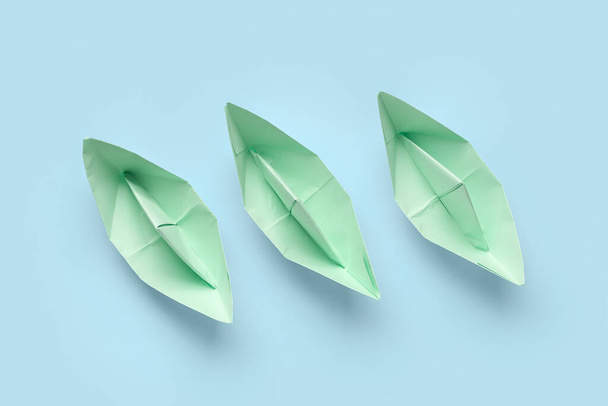 Green origami boats on blue background - Photo, Image