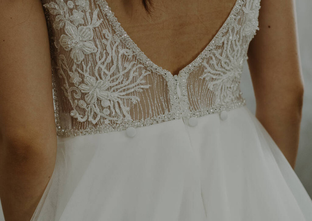 Krásný výhled na krajkové svatební šaty na holých zádech nevěsty, zblízka boční pohled. - Fotografie, Obrázek