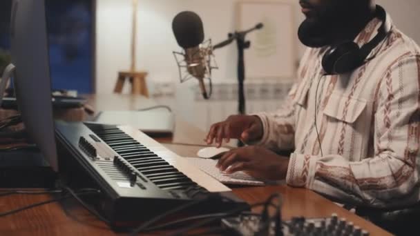 Strak medium shot van Afro-Amerikaanse man zet zijn koptelefoon op, luisteren tevreden naar zijn audio-record - Video