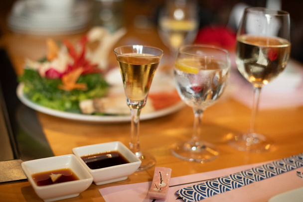 stół ustawienie japońskiej restauracji teppanyaki. świeże figurujące warzywa i kieliszki wina - Zdjęcie, obraz
