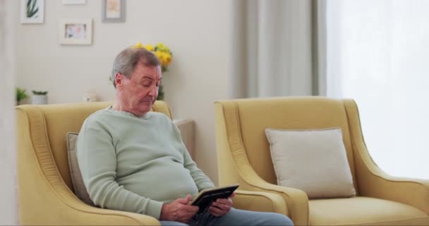 Home, thinking and old man with tablet, connection and retirement with memory, app and social media. Pensioner on a couch, relax and senior person with technology, wellness or ideas with nostalgia. - Footage, Video