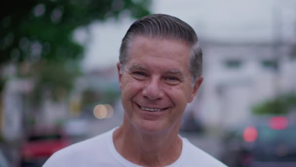 Veselý starší muž kráčí sebevědomě ke kameře venku na City Street s úsměvem - Záběry, video