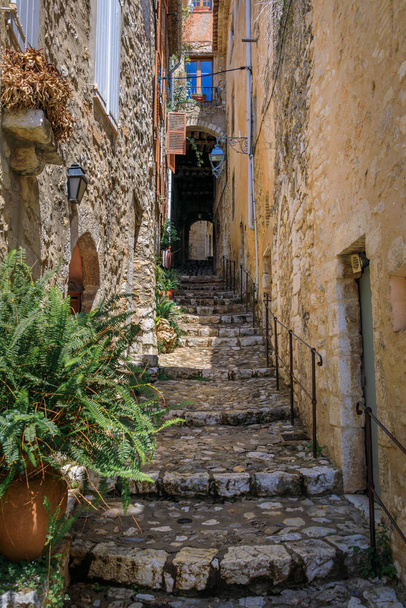 Tradizionali vecchie case in pietra su una ripida stradina con gradini nella città medievale di Saint Paul de Vence, Costa Azzurra, Sud della Francia - Foto, immagini