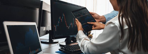 Group of traders discussing on office desk, monitoring stock market on monitor at office workplace. Businessman and broker analyzing stock graph together at stock trading company. Trailblazing - Photo, Image