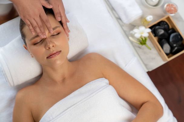 Panoramatický pohled na ženu, která si užívá relaxační antistresovou masáž hlavy a hýčkání pleti kosmetické rekreace v denním lázeňském moderním světlém prostředí v luxusním resortu nebo hotelovém lázeňském salonu. Tichý - Fotografie, Obrázek