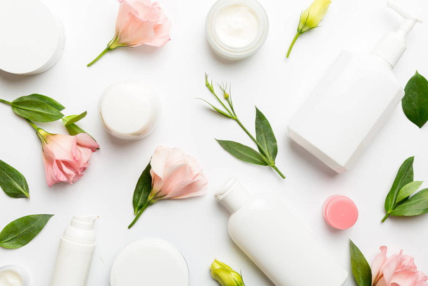 Composition with cosmetic products and beautiful roses on white background. Flat lay. - Photo, Image