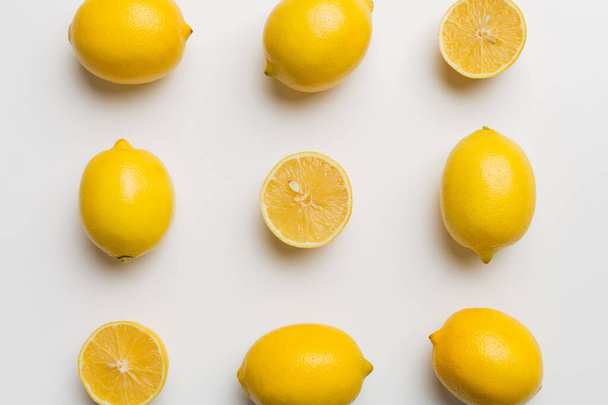 Many fresh ripe lemons as colored background, top view. Elegant background of lemon and lemon slices Top view flat lay. - Photo, Image