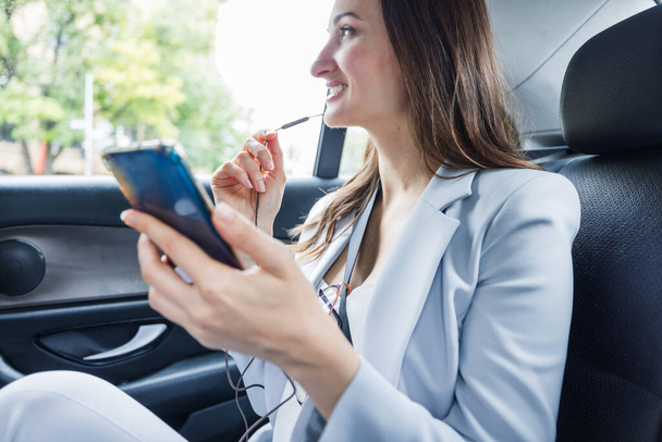 Geschäftsfrau im Taxi telefoniert mit ihrem Handy - Foto, Bild