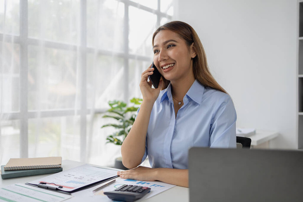 Asian woman talking on the phone in startup company office, businesswoman senior executive company executive talking on the phone in office room, business negotiation. Business administration concept. - Photo, Image