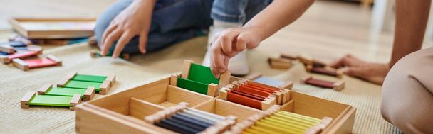 concepto de la escuela montessori, vista recortada de niña jugando juego de combinación de colores cerca del profesor, bandera - Foto, Imagen