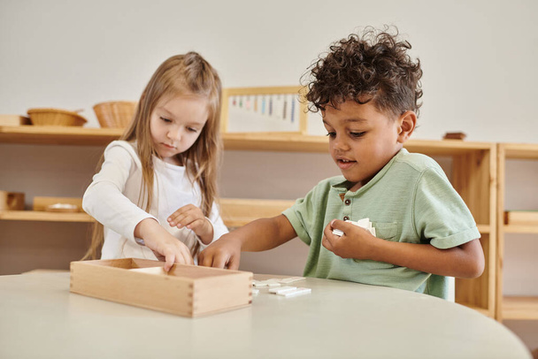 aprendizaje matemático, niño afroamericano jugando con chica, concepto de escuela montessori, diversos niños - Foto, imagen