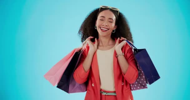 Luxury, shopping bag and smile with woman in studio for designer boutique, retail and wardrobe. Product, choice and fashion brands with customer on blue background for promotion, gift and sales. - Footage, Video